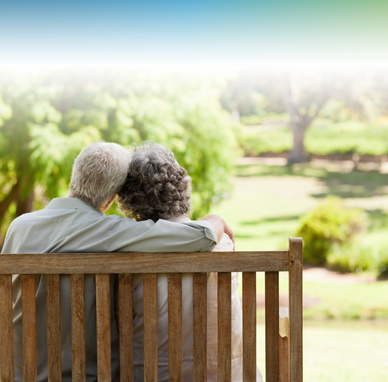 the backs of an older couple on bench